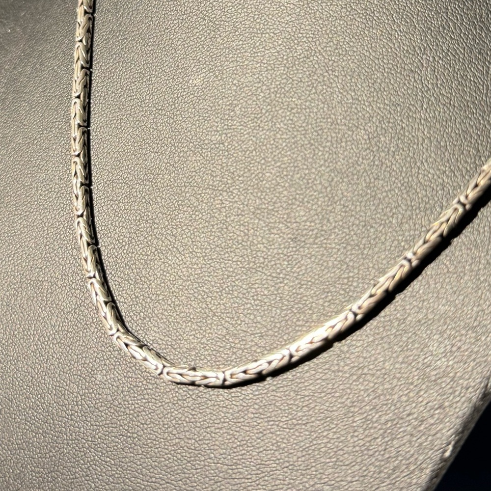 Silver necklace with rounded chain and hook clasp closure.